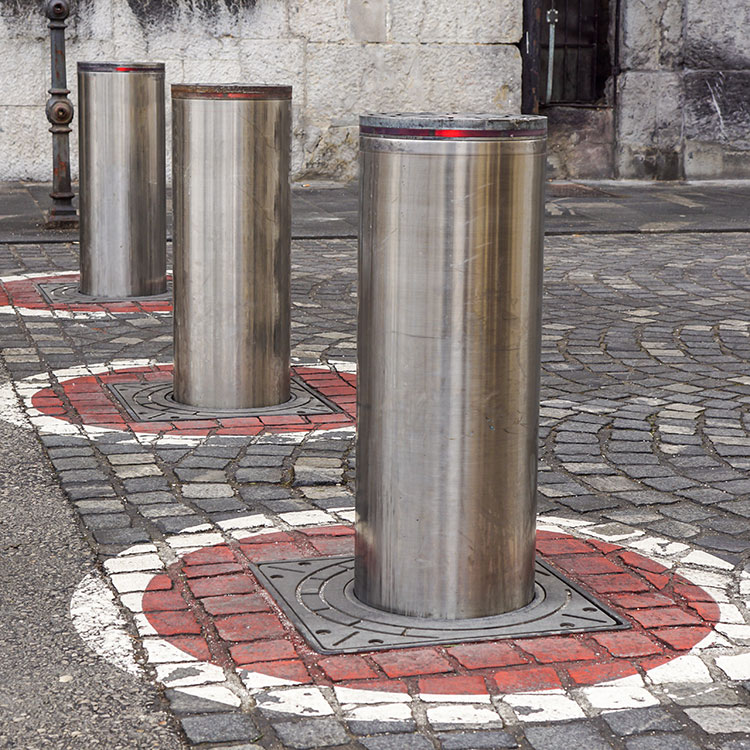 Automatic crash rated bollards with beacons blocking access to a road