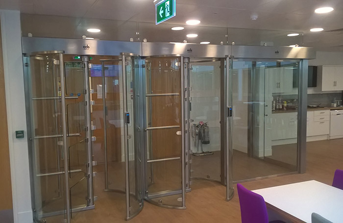 Photo of full height glass turnstile gates in an office building