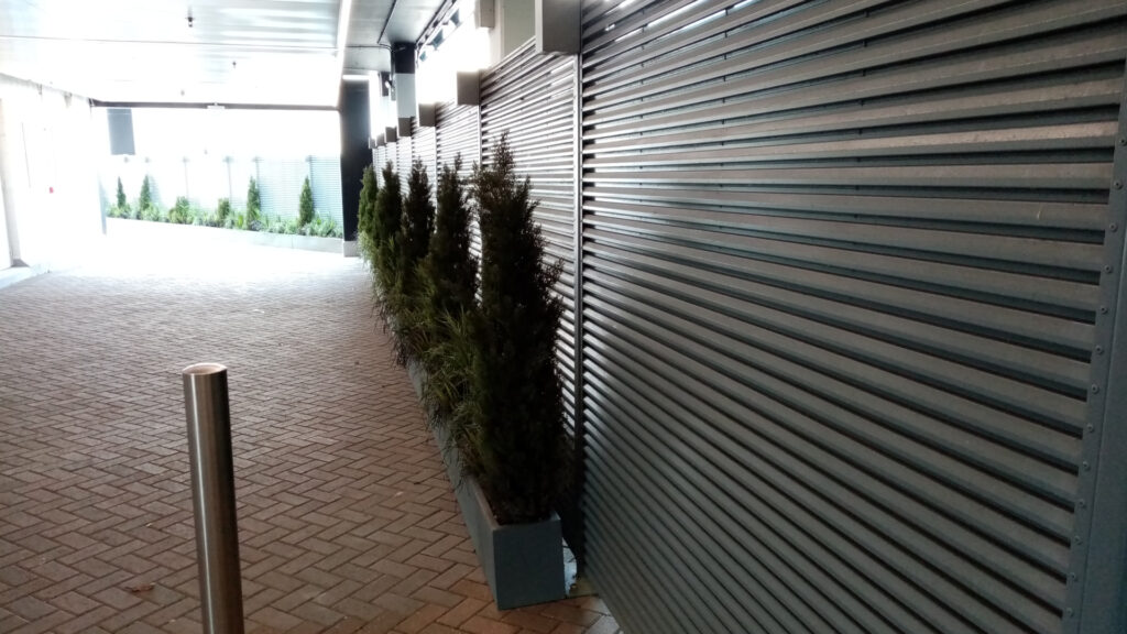 Louvered fence wall with planters