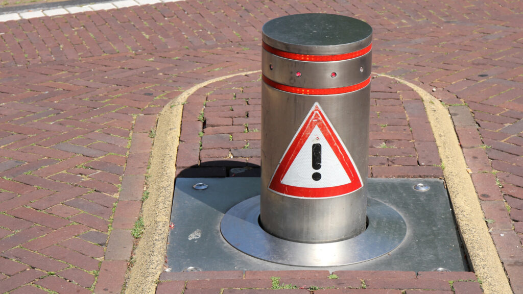 Automatic crash rated bollard with warning sign
