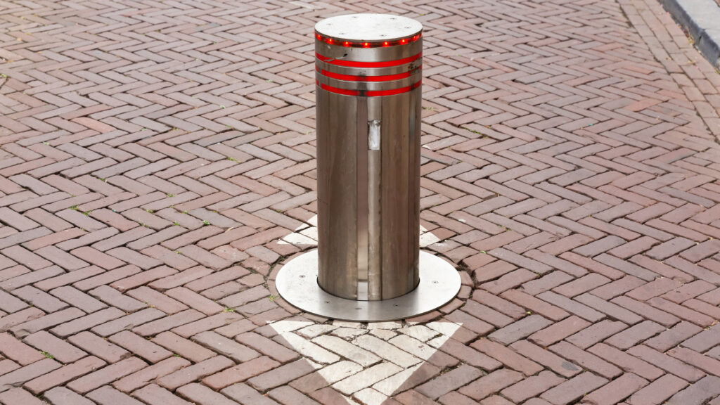 Automatic crash rated bollard with a beacon on a road
