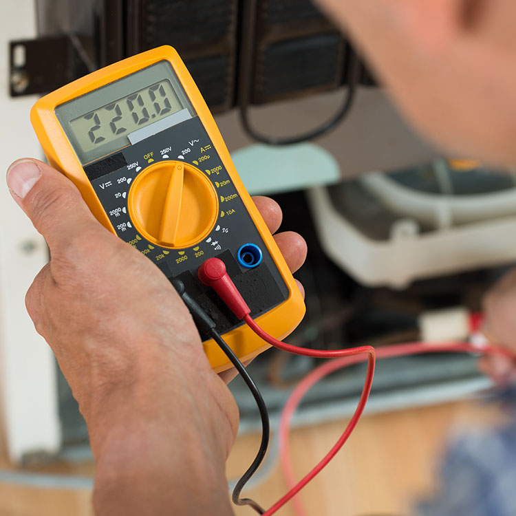 Electrician using a multimeter to test a circuit