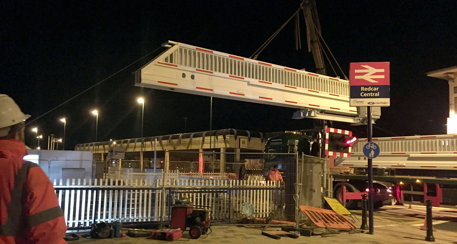 Photo of specialist crane lifting new level crossing gate into position at Redcar Central station