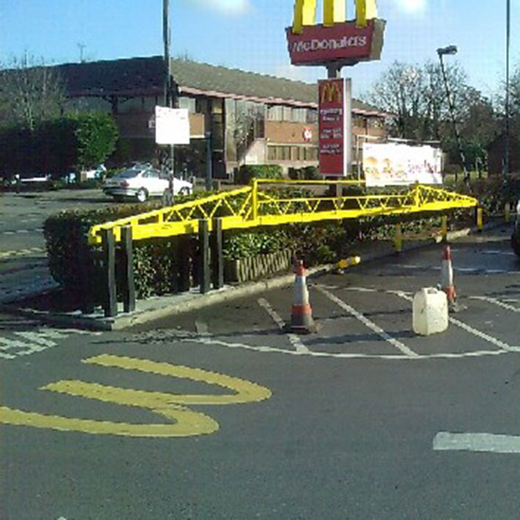 Automatic sliding traffic barrier at entrance to McDonalds car park
